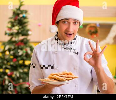 Le jeune chef mari travaillant en cuisine à la veille de Noël Banque D'Images