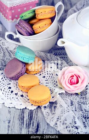 Macarons sur la serviette et dans la tasse sur table en bois gros plan Banque D'Images