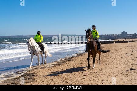 Portobello, Écosse, Royaume-Uni. 19 avril 2020. Cheval de police monté Logie et Édimbourg - en blanc, patrouillent la promenade et la plage de Portobello le dimanche après-midi ensoleillé. Iain Masterton/Alay Live News Banque D'Images