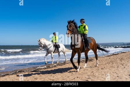 Portobello, Écosse, Royaume-Uni. 19 avril 2020. Cheval de police monté Logie et Édimbourg - en blanc, patrouillent la promenade et la plage de Portobello le dimanche après-midi ensoleillé. Iain Masterton/Alay Live News Banque D'Images