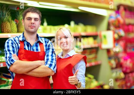 personnel souriant de l'épicerie travaillant dans un supermarché Banque D'Images