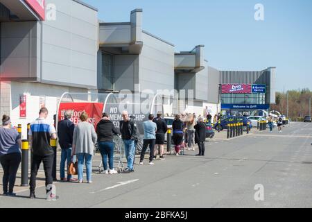 Glasgow, Royaume-Uni. 19 avril 2020. Photo : de longues files d'attente attendent les clients en dehors des magasins B&M pendant un week-end chaud et ensoleillé sous le verrouillage de Coronavirus (COVID-19). Les distanciation sociale peuvent être considérées comme des files d'attente de personnes. Au Royaume-Uni, les cas confirmés de personnes infectées sont 120 067 et 16 060 décès. Crédit : Colin Fisher/Alay Live News Banque D'Images