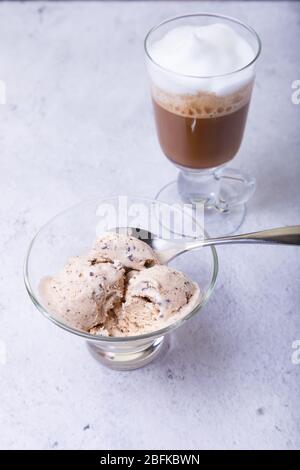 Glace maison avec chips de chocolat dans un bol. Trois boules de glace et une tasse de café. Gros plan. Banque D'Images