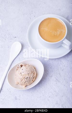 Glace maison avec chips de chocolat dans un bol. Une boule de glace et une tasse de café. Gros plan. Banque D'Images