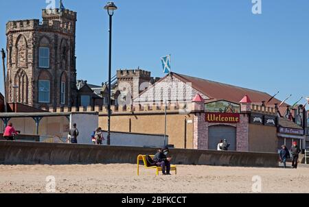 Plage de Portobello, Édimbourg, Écosse. 19 avril 2020. Les gens qui font leurs exercices quotidiens sur la plage par temps ensoleillé, une nageur sauvage féminine bravant le surf fraisky, moins de gens qu'hier, comme le Lockdown de Coronavirus continue, Cependant, la Promenade était animée avec des cyclistes comme toujours, plus que la plage, bien que la plage de sable puisse être plus facile pour les marcheurs à s'isoler. Température de 10 degrés avec un vent ENE de 17 km/h de rafale potentielle de 33 km/h. Crédit: Arch White/Alay Live News. Banque D'Images