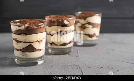 Tiramisu traditionnel en verre. Dessert fait de fromage mascarpone aux ladydoigts et de poudre de cacao. Délicieux, savoureux et sucré Banque D'Images