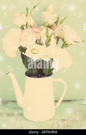 Belles fleurs d'eustoma dans le teapot, sur fond de couleur Banque D'Images