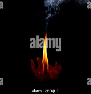 flamme lumineuse bougie brûlant de la fumée vive sur fond noir Banque D'Images
