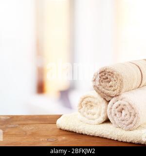 Serviettes de bain laminées sur table en bois dans la salle de bains Banque D'Images