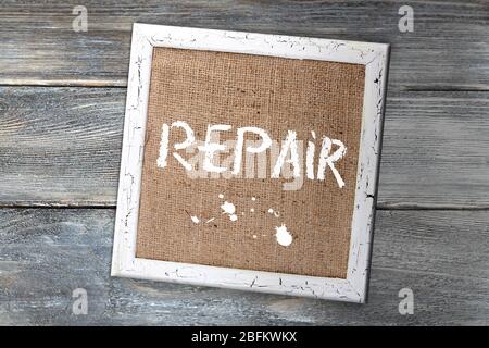 Panneau en bois avec texte réparation sur fond de mur en bois Banque D'Images