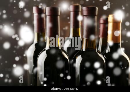 Bouteilles de vin en rangée sur fond de bois sur effet neige Banque D'Images