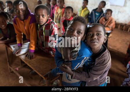 Les enfants de l'école accueillent les visiteurs dans leur maison d'école à un étage de terre de terre de saleté à Dorze, en Ethiopie, en Afrique. Banque D'Images