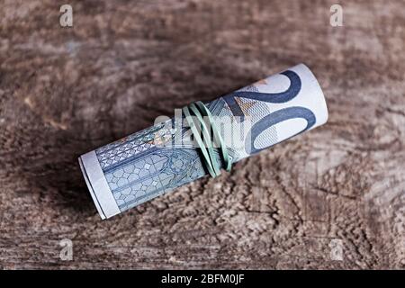 Rouleau de billets sur fond de bois Banque D'Images