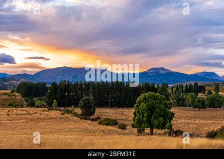 Vue sur la ferme contre les montagnes au coucher du soleil à Trevelin, Patagonie, Argentine Banque D'Images