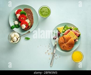 Petit-déjeuner servi avec jus de fruits et sandwichs, jambon, fromage, tomate et laitue. Continental délicieux table de petit déjeuner saine Banque D'Images