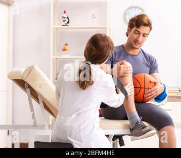 Le beau joueur de basket-ball féminin en visite médecin traumatologist Banque D'Images