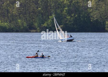 Haltern am See, NRW, Allemagne. 19 avril 2020. Les gens prennent leurs dingchies et kayaks sur le lac Haltern, un lieu de loisirs populaire de week-end et le lac de baignade. Les TSR et certains sports nautiques sont autorisés tant que les étrangers ne se tiennent pas à des règles de distanciation, les membres d'un ménage sont exclus. Dans l'ensemble, les Allemands ont jusqu'à présent assez bien respecté les règles et restrictions de distanciation sociale à la vie publique, les taux d'infection se nivelant lentement et tôt indiquant que les mesures fonctionnent. Crédit: Imagetraceur/Alay Live News Banque D'Images