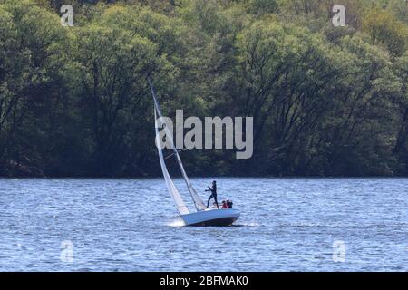 Haltern am See, NRW, Allemagne. 19 avril 2020. Les gens prennent leurs dingchies et voiliers sur le lac Haltern, un lieu de loisir populaire de week-end et un lac de baignade. Les TSR et certains sports nautiques sont autorisés tant que les étrangers ne se tiennent pas à des règles de distanciation, les membres d'un ménage sont exclus. Dans l'ensemble, les Allemands ont jusqu'à présent assez bien respecté les règles et restrictions de distanciation sociale à la vie publique, les taux d'infection se nivelant lentement et tôt indiquant que les mesures fonctionnent. Crédit: Imagetraceur/Alay Live News Banque D'Images