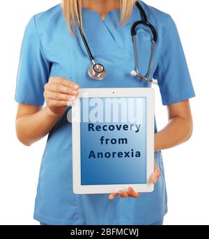 Médecin féminin avec tablette pc et texte récupération d'Anorexia à l'écran isolé sur blanc Banque D'Images