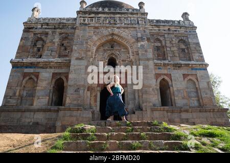 Le touriste blond pose à la tombe de Sheesh Gumbad tombe dans les jardins de Lodi à New Delhi, en Inde Banque D'Images