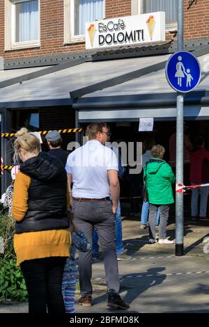 Haltern am See, NRW, Allemagne. 19 avril 2020. Une longue file d'attente s'est formée en dehors de la Glacière italienne, avec des gens qui se trouvent à distance et pas plus de 2 permis en tout temps. Dans l'ensemble, les Allemands ont jusqu'à présent assez bien respecté les règles et restrictions de distanciation sociale à la vie publique, les taux d'infection se nivelant lentement et tôt indiquant que les mesures fonctionnent. Crédit: Imagetraceur/Alay Live News Banque D'Images