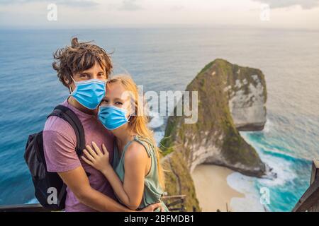 Vie de vacances en famille. Couple heureux - l'homme et la femme dans le masque médical se tiennent au point de vue. Regardez la belle plage sous la haute falaise. Voyage Banque D'Images