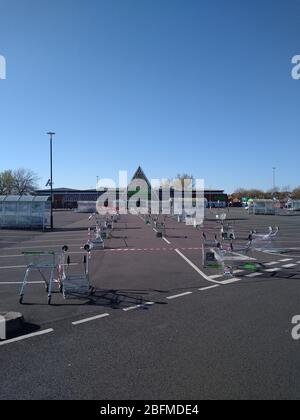 Un supermarché ASDA à St Helens, au Royaume-Uni, utilise une ligne de chariots/chariots dans son parking pour maintenir les clients socialement éloignés en raison du virus COVID-19. Banque D'Images