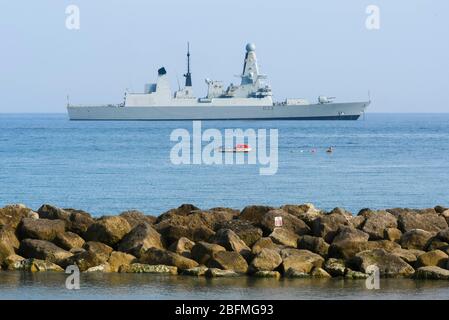 Lyme Regis, Dorset, Royaume-Uni. 19 avril 2020. Météo britannique. Royal Navy Type 45 Destroyer HMS Daunless ancré à Lyme Regis à Dorset un après-midi ensoleillé pendant le verrouillage de la pandémie de coronavirus. Crédit photo : Graham Hunt/Alay Live News Banque D'Images