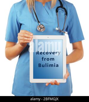 Médecin féminin avec tablette pc et texte récupération de Bulimia à l'écran isolé sur blanc Banque D'Images