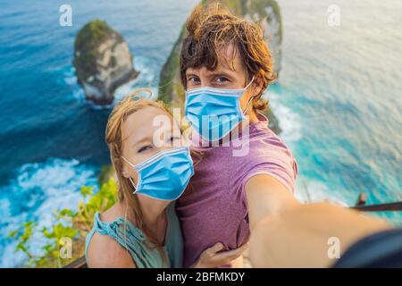 Vie de vacances en famille. Couple heureux - l'homme et la femme dans le masque médical se tiennent au point de vue. Regardez la belle plage sous la haute falaise. Voyage Banque D'Images