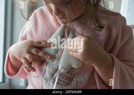 Jeune fille belle avec cheveux sombre séjour dans robe rose et prendre deux coeurs de porcelaine blanche. Signe d'amour à Saint Valentin ou fête des mères. Banque D'Images