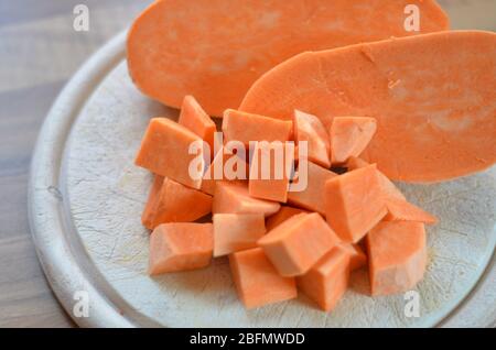 des cubes de pommes de terre douces sur une planche à découper, cuisinant avec des patates douces comme légumes de rechange Banque D'Images