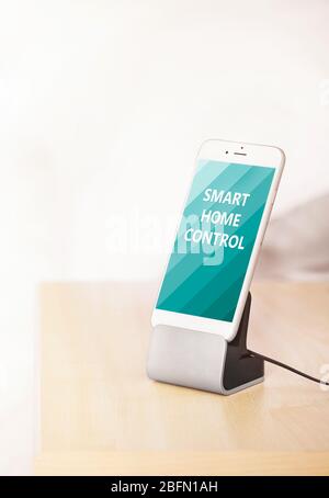 Concept de contrôle intelligent à domicile. Smartphone près du lit Banque D'Images