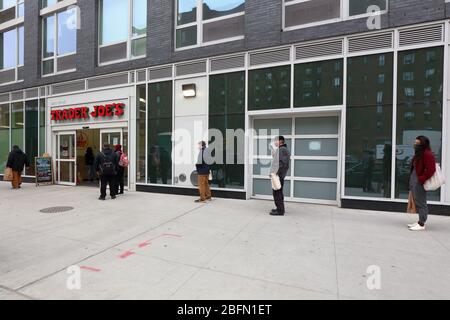 Les personnes portant des masques et des distanciation sociale lorsqu'elles font la queue pour entrer dans un supermarché pendant le covid de coronavirus 19. New York, NY, 17 avril 2020. Banque D'Images