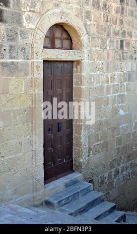 Des marches mènent à la porte d'un bâtiment en pierre dans la ville historique de Victoria, la capitale de l'île de Gozo à Malte. Banque D'Images