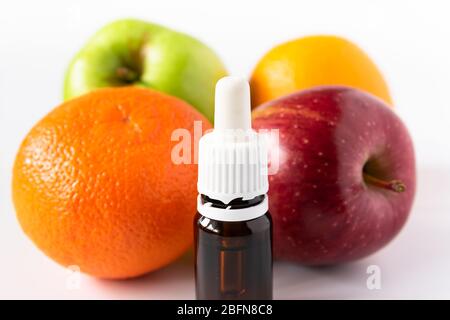 concept cosmétique, bouteille de verre avec sérum avec acides alpha hydroxy sur un fond de fruits Banque D'Images