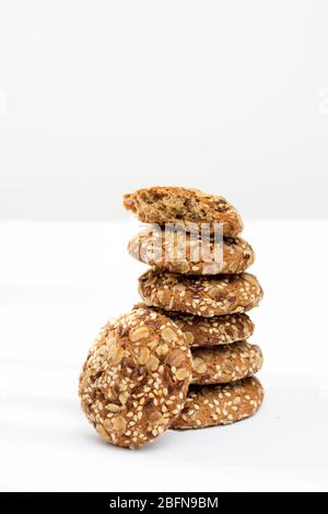 Les biscuits au gruau saupoudrés de graines de sésame et d'amandes sur une table contre un mur gris dans la cuisine. Espace de copie Banque D'Images