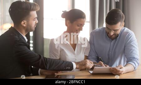 Couple et représentant de la banque parviennent à un accord de signature de contrat de prêt Banque D'Images