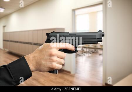 Homme avec pistolet à la salle d'école Banque D'Images