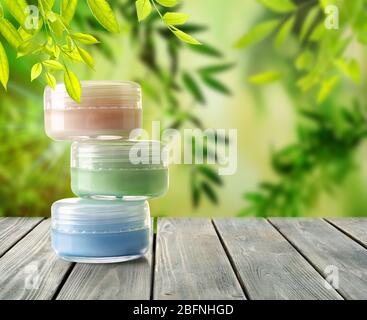 Cosmétique naturelle sur table en bois contre fond de feuillage vert Banque D'Images