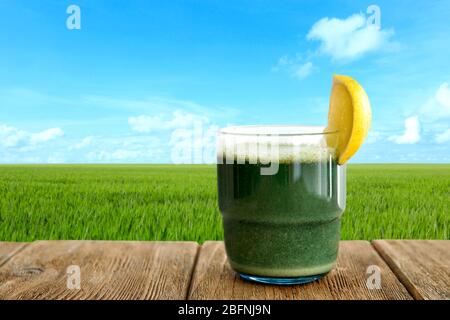 Verre de jus et champ d'herbe de blé sur fond Banque D'Images