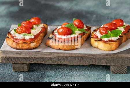 Bruschettas italiens avec mozzarella, riccotta, tomates cuites et basilic Banque D'Images