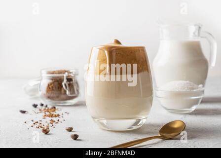 Café Dalgona maison en verre avec des ingrédients. Recette populaire de café coréen au latte avec mousse de café instantané. Banque D'Images