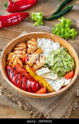 Bol avec poulet grillé, riz, fromage bleu et légumes Banque D'Images