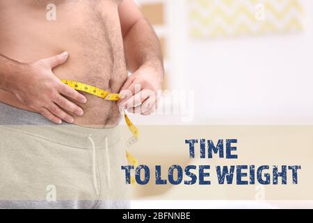 Motivation citation TEMPS DE PERDRE DU POIDS et l'homme en surpoids mesurant la taille contre fond flou Banque D'Images