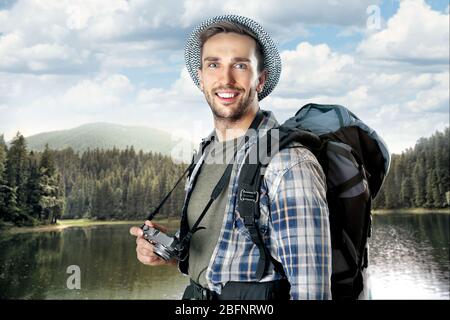 Jeune homme avec appareil photo sur un magnifique paysage Banque D'Images