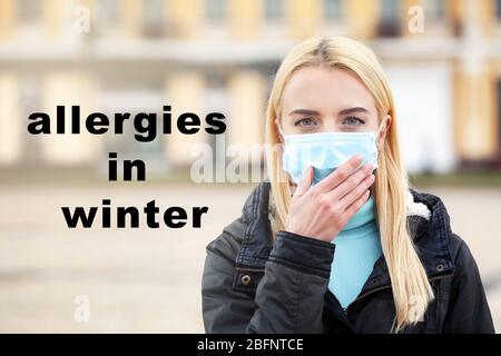 Texte ALLERGIES EN HIVER sur fond. Femme malade dans le masque facial, extérieur Banque D'Images