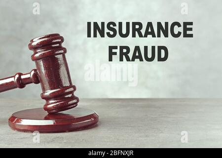 Concept de fraude d'assurance. Le gavel du juge à la table Banque D'Images