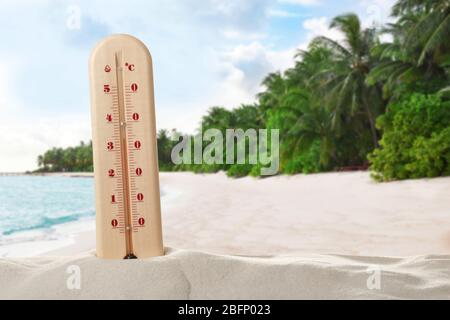 Thermomètre indiquant une température élevée sur la plage tropicale. Temps chaud d'été Banque D'Images