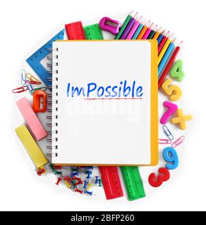 Mot impossible transformé en possible sur la page de bloc-notes avec des fournitures scolaires Banque D'Images